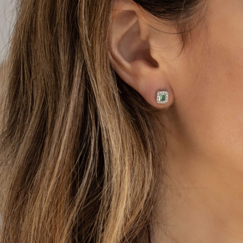 art deco style emerald and diamond studs in woman's ear