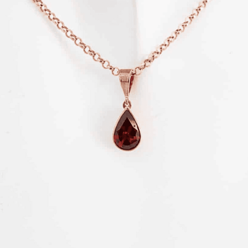 contemporary 9ct rose gold and garnet pendant and chain on mannequin neck