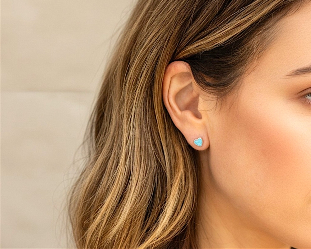 silver and light blue heart shaped opal studs for sale in Leeds in model's ear