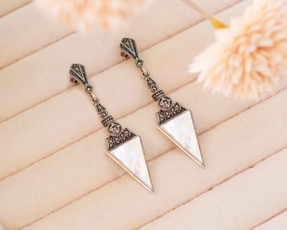 mother of pearl earrings art deco style mother of pearl earrings in silver with marcasite stones, shown on a pink tray