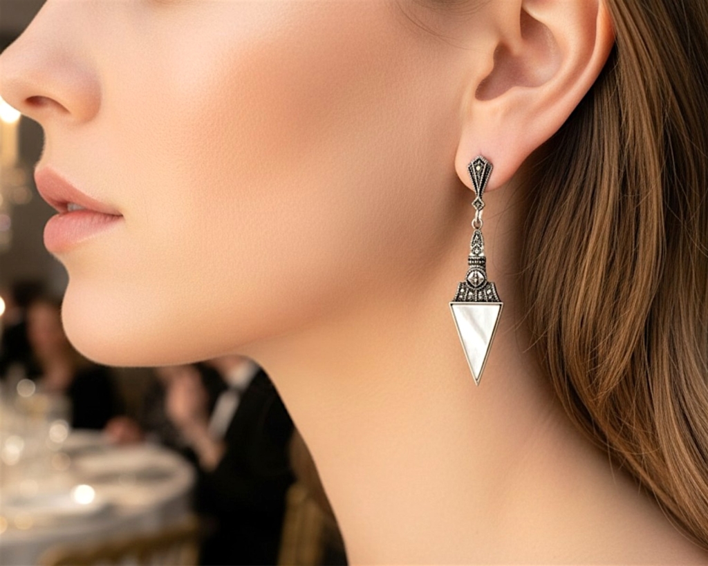 art deco style mother of pearl earrings in silver with marcasite stones, shown on a model