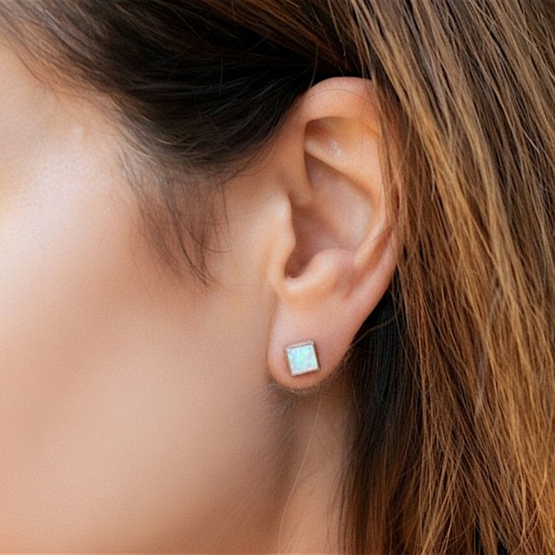 silver and white opal square shaped studs for sale in leeds shown in model's ear