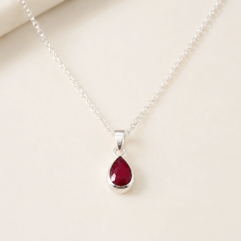 silver and ruby pendant in a pear cut shape