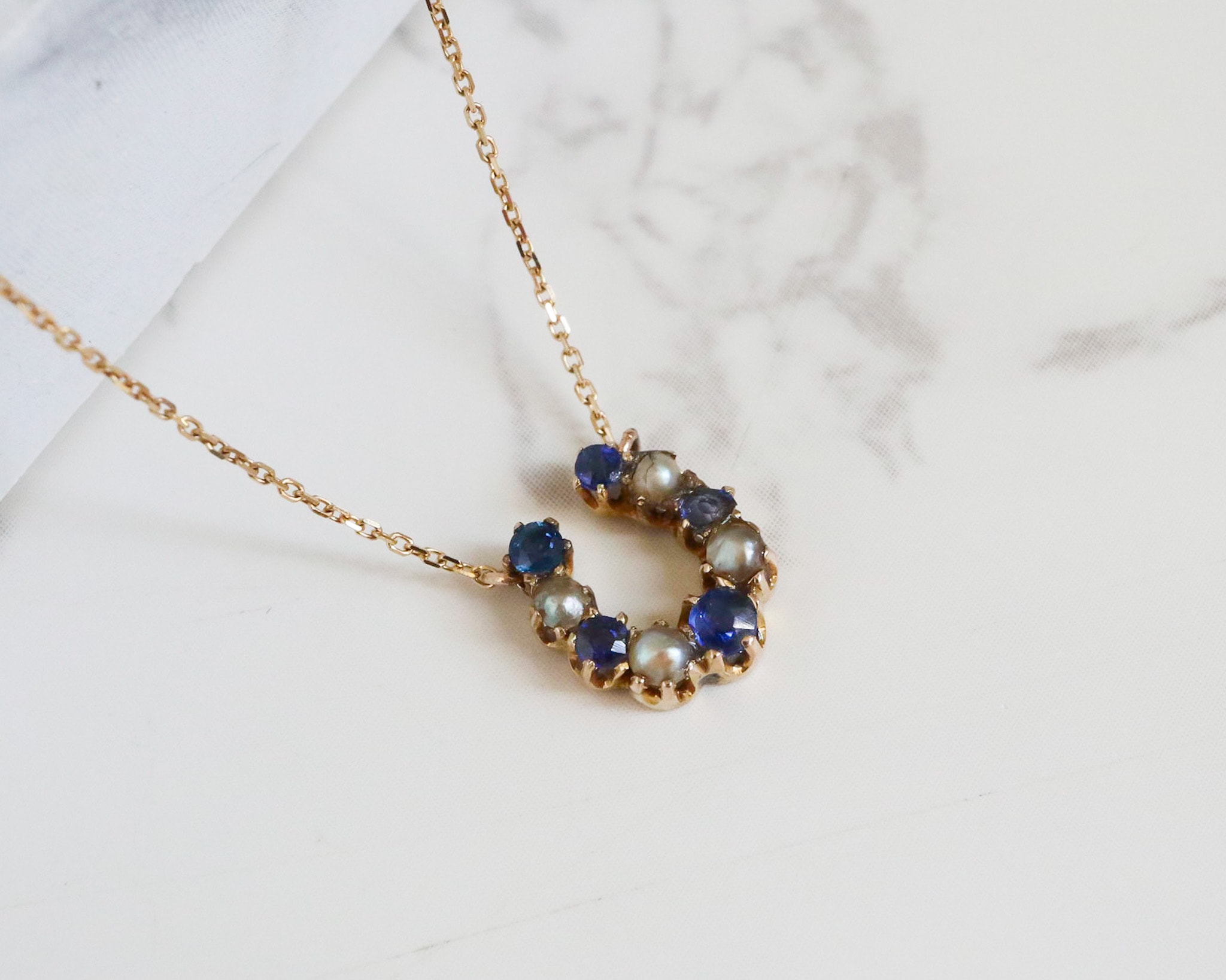 antique sapphire and seed pearl horseshoe pendant on a 16 inch integral gold chain. Edwardian stick pin conversion