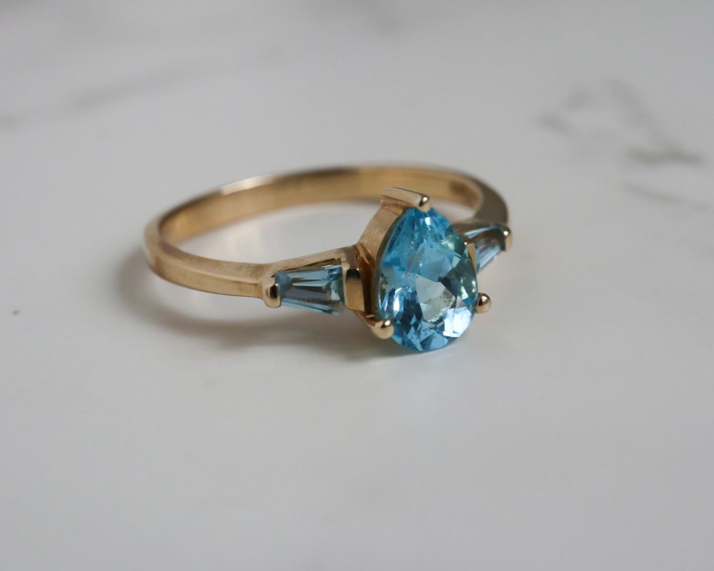 Vintage blue topaz ring set in 9ct yellow gold. Pear cut and baguette cut blue topaz stones