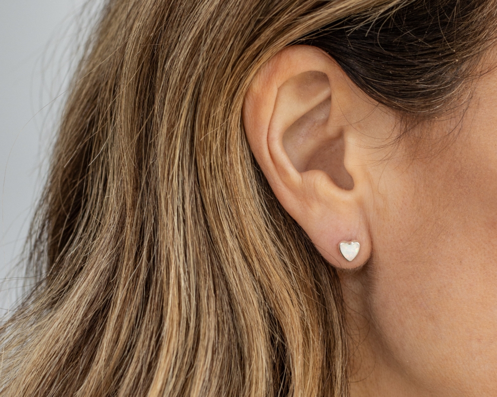 white opal and silver studs in ear