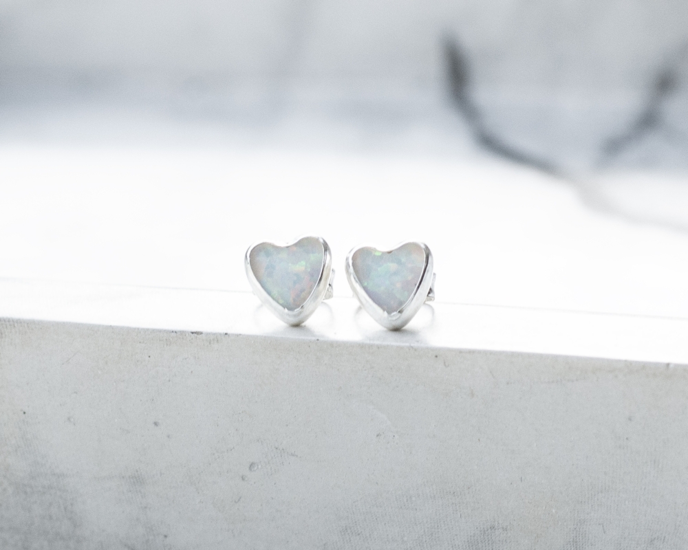 a pair of silver and white opal stud earrings for pierced ears.