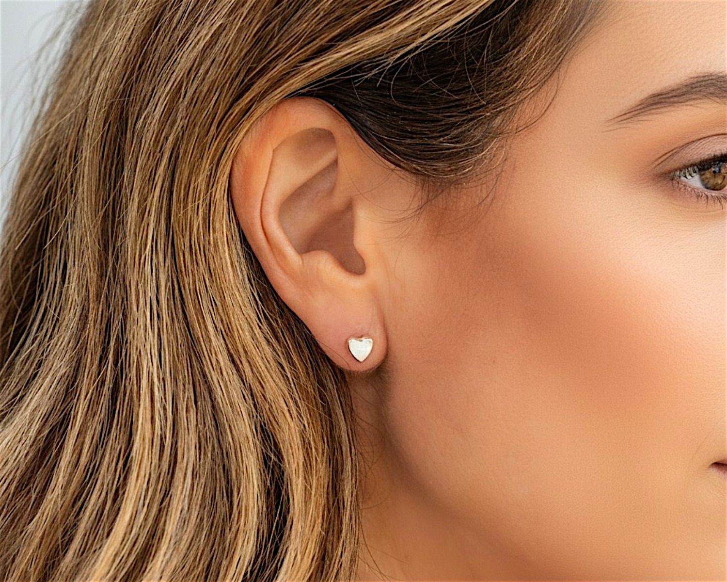 white opal heart studs in model ear