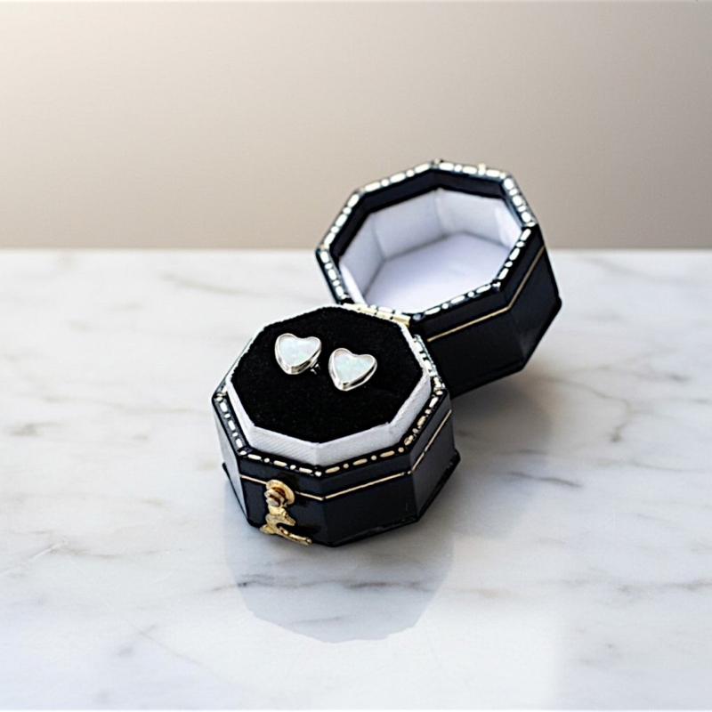 white opal heart studs in silver in a black box