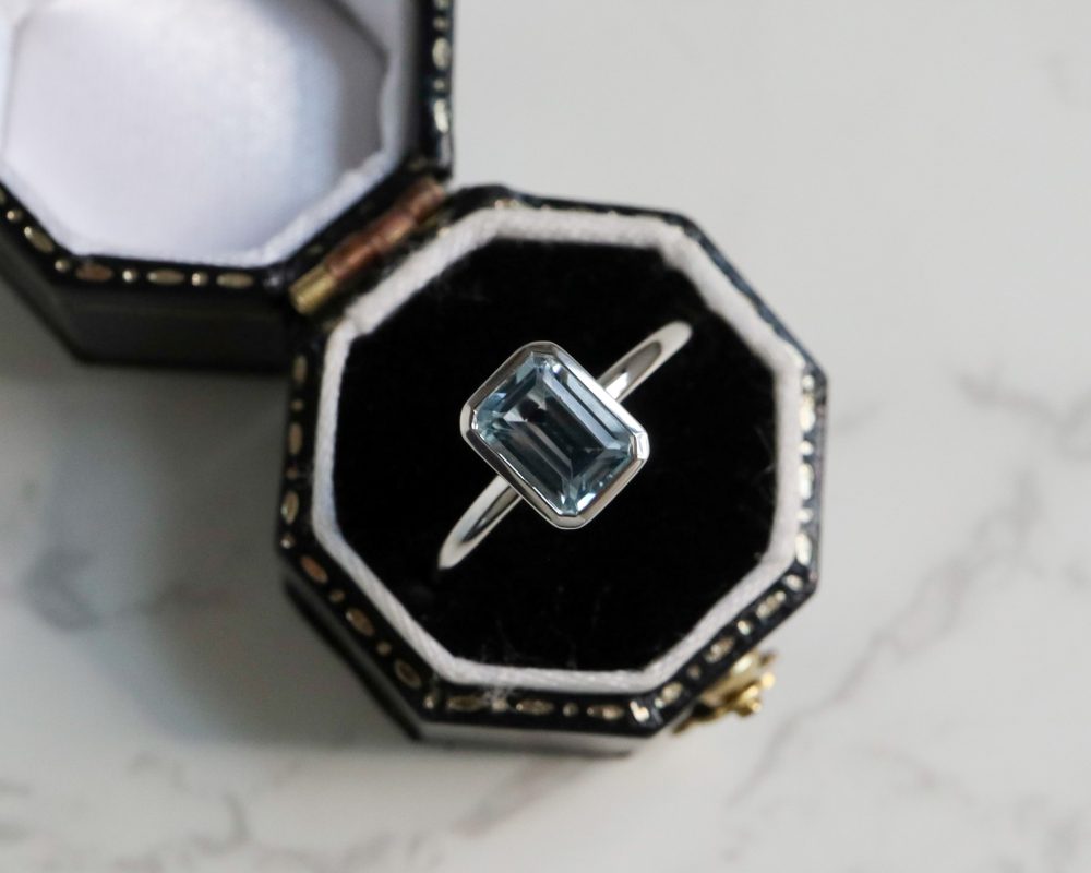 9ct white gold and blue topaz emerald cut ring in a bezel setting