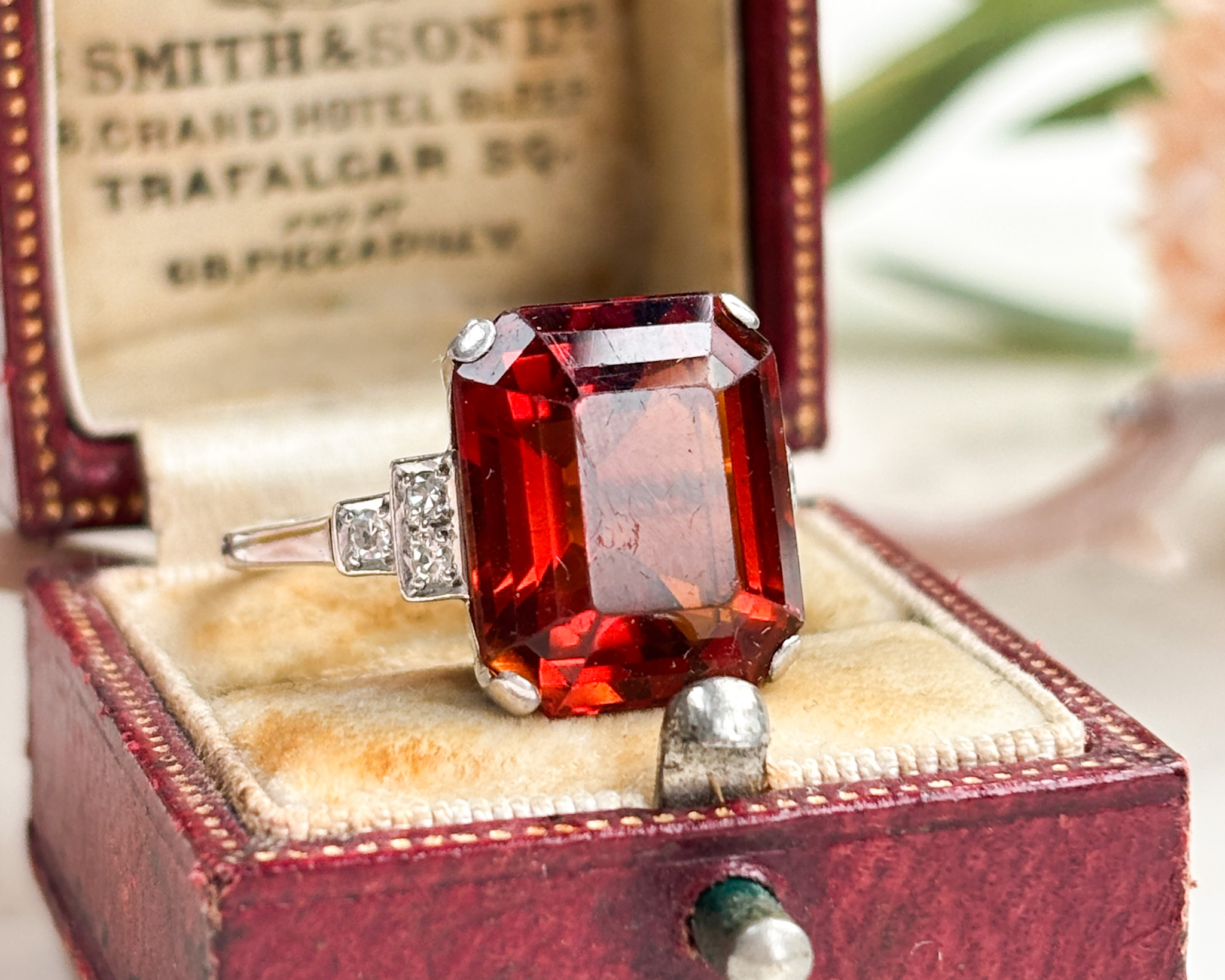 art deco Madeira citrine emerald cut ring with diamond shoulders set in 18ct white gold and platinum. Shown on top of a presentation box