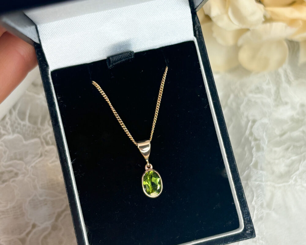 modern 9ct rose gold and oval shaped peridot pendant on an 18 inch chain for sale