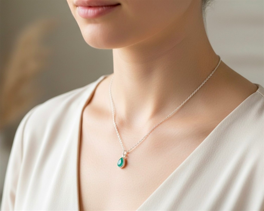 pear cut silver emerald pendant on model's neck