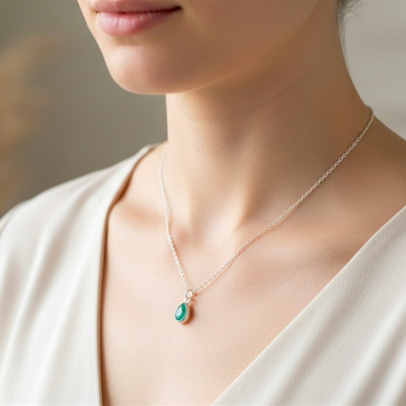 pear cut silver emerald pendant on model's neck