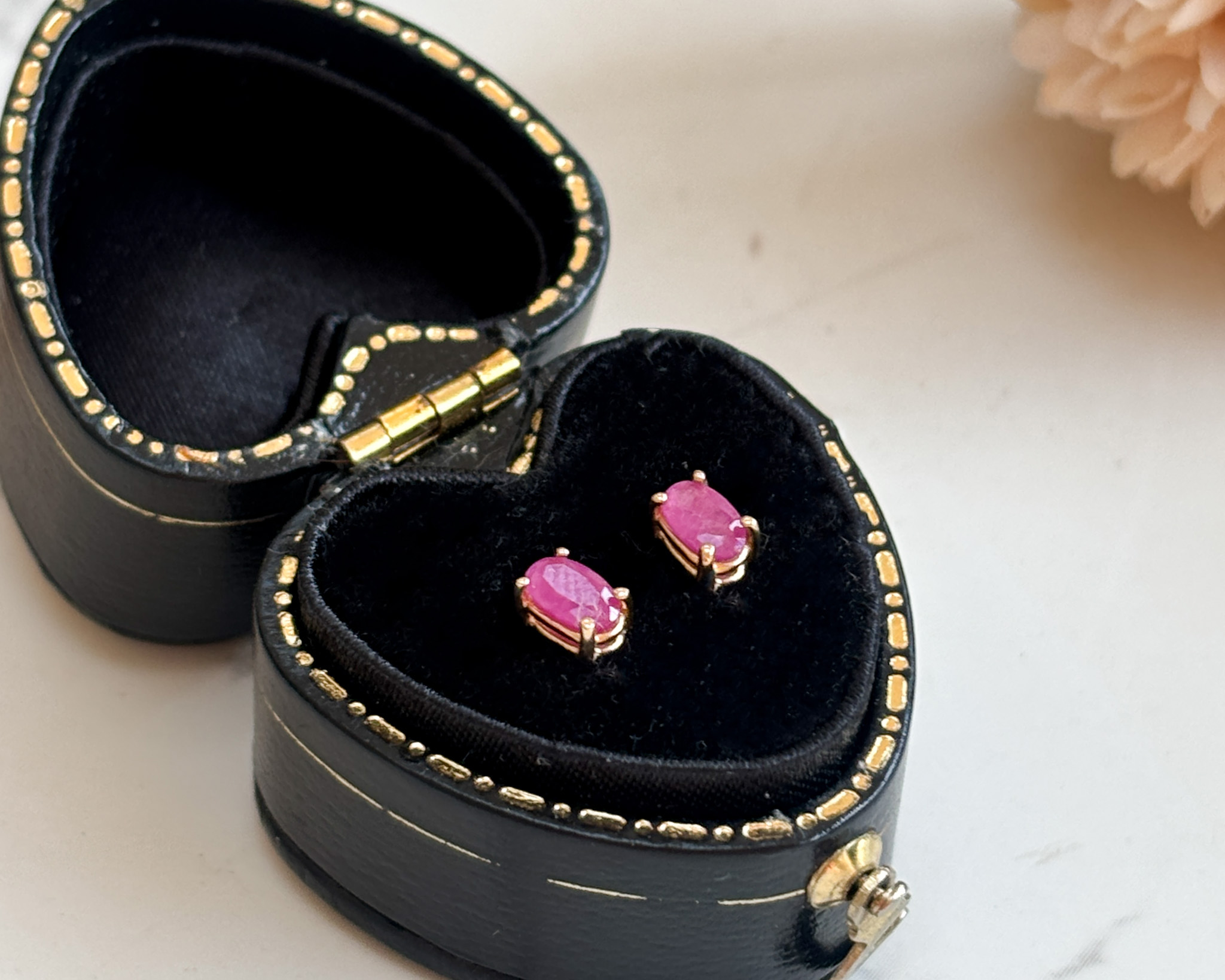 modern ruby stud earrings for sale. Oval pinkish ruby earrings in a claw setting for pierced ears.