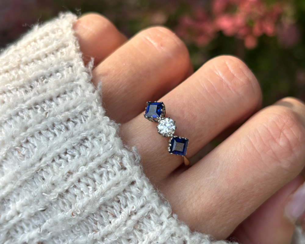 antique Art Deco sapphire and diamond three stone ring with old cut diamond and square cut sapphires for sale in Leeds, Yorkshire shown on a lady's finger