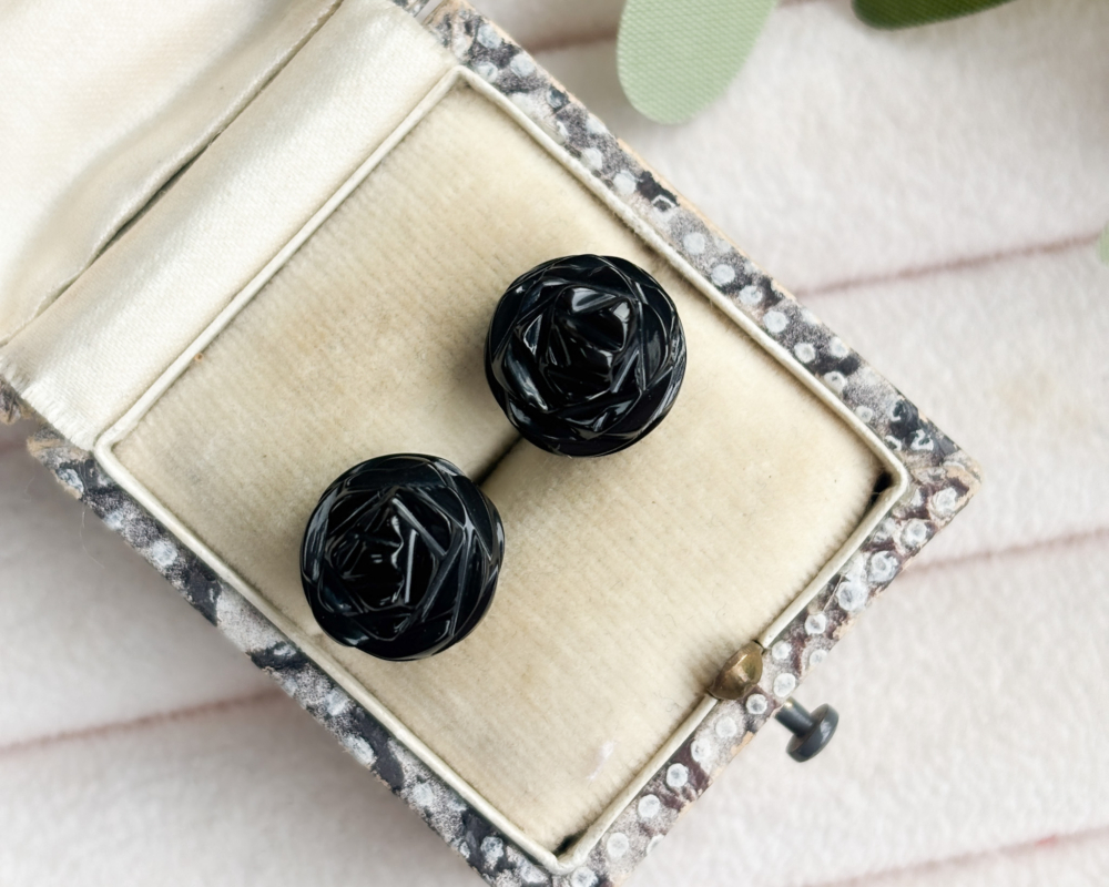 antique Whitby Jet stud earrings with silver backs shown in a presentation box