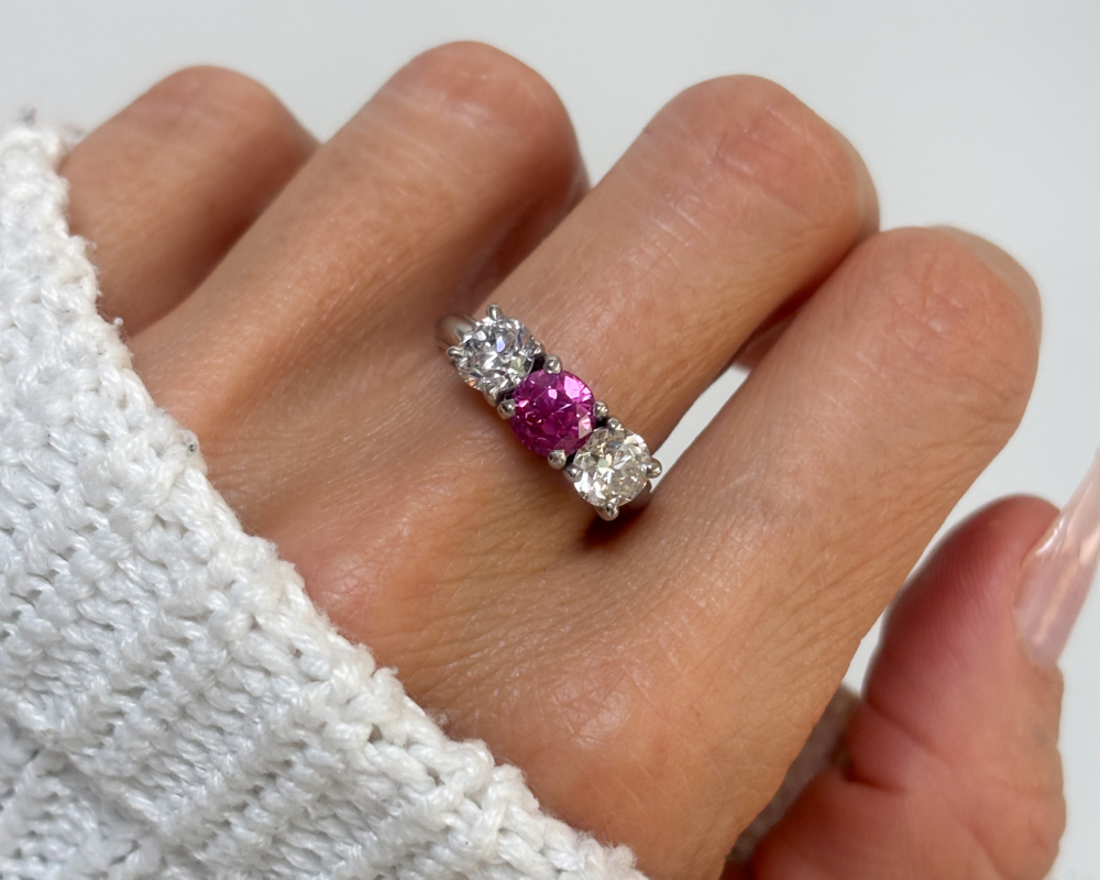 1940s untreated and natural pink sapphire and diamond three stone ring in platinum, for sale in Leeds, Yorkshire shown on lady's finger