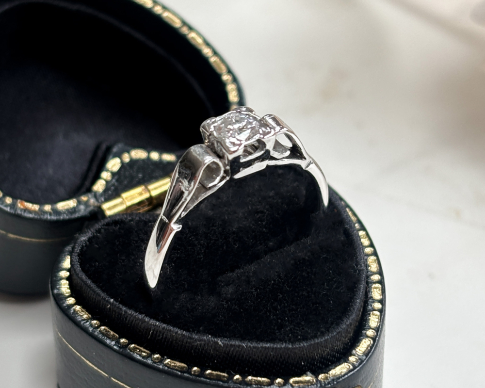 art deco diamond ring with a square setting, in 18ct white gold and platinum showing the underside of the ring in a presentation box