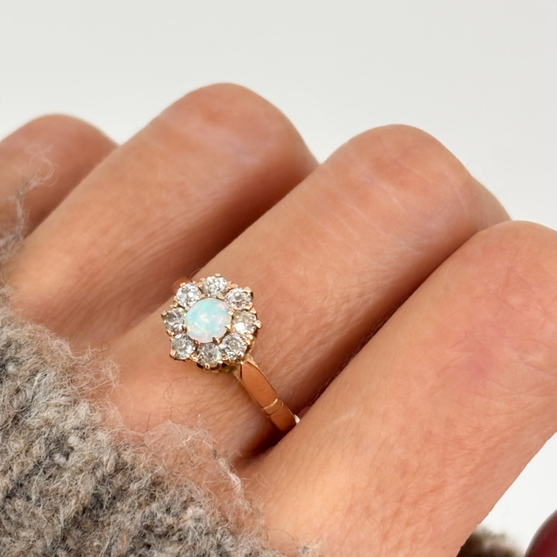 antique opal and diamond cluster ring from the Edwardian era, set in 15ct gold, shown on lady's finger