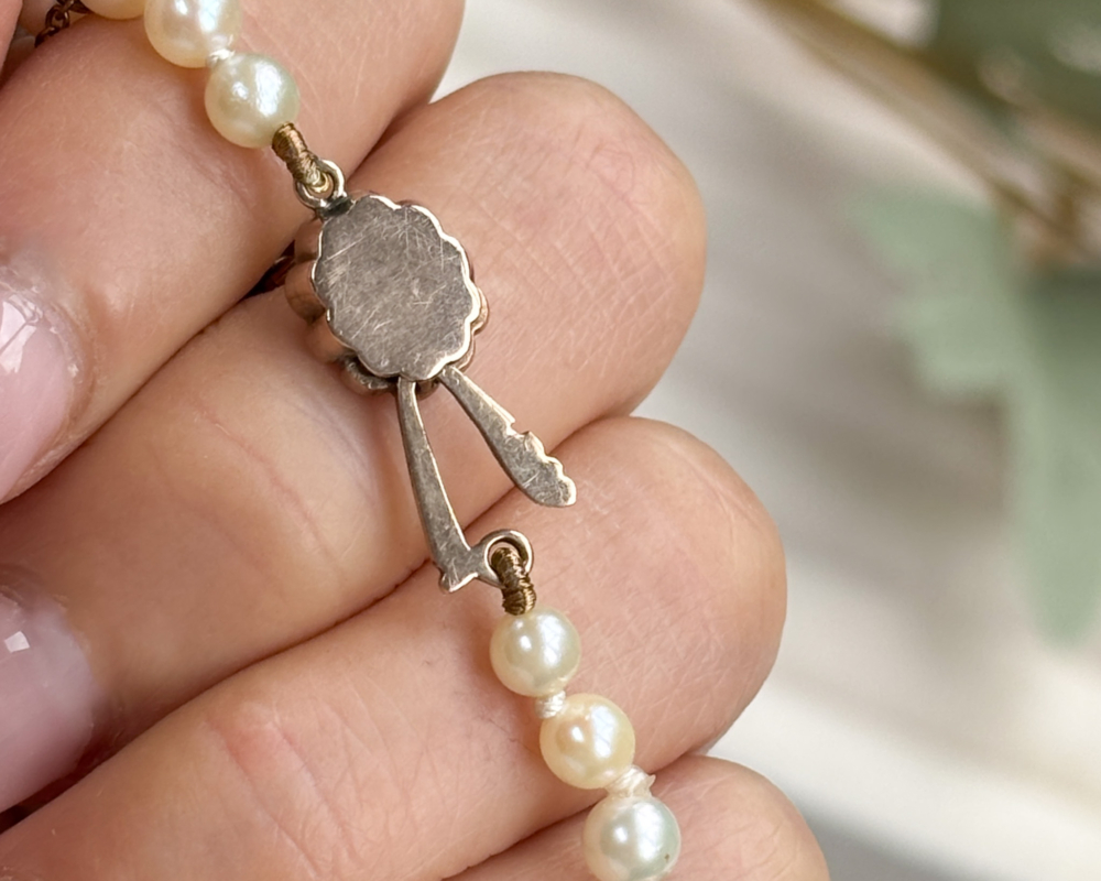 antique 1920s cultured pearl necklace with 9ct gold and pink paste clasp, shown in box, showing back of the clasp