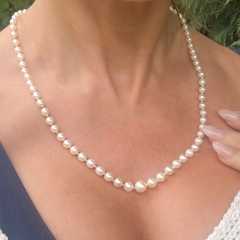 antique 1920s cultured pearl necklace with 9ct gold and pink paste clasp, shown on lady's neck