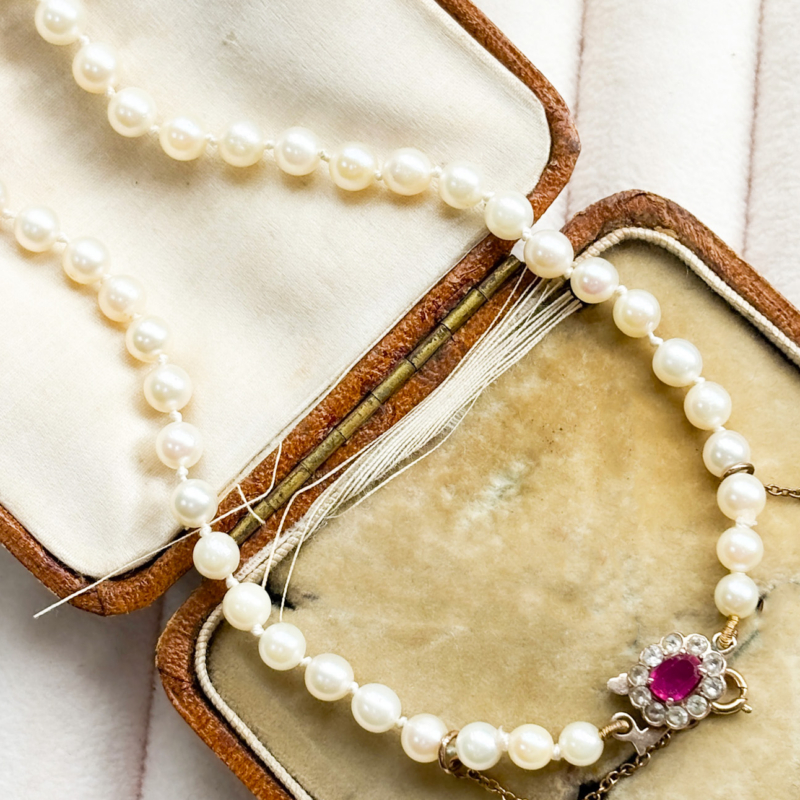 antique 1920s cultured pearl necklace with 9ct gold and pink paste clasp, shown in box