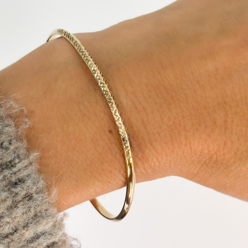 vintage 9ct gold bangle with engraved pattern for sale in Leeds, shown on woman's hand