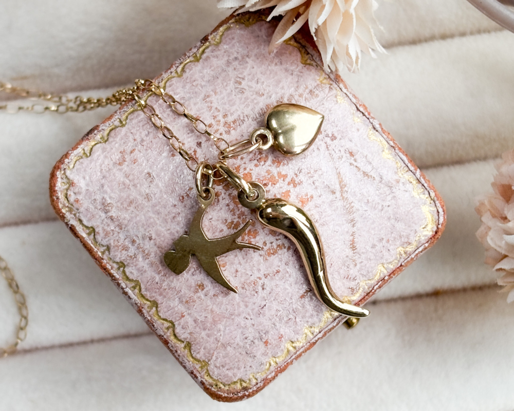 vintage 9ct gold charm necklace with heart charm, horn of plenty and bird on a gold chain.