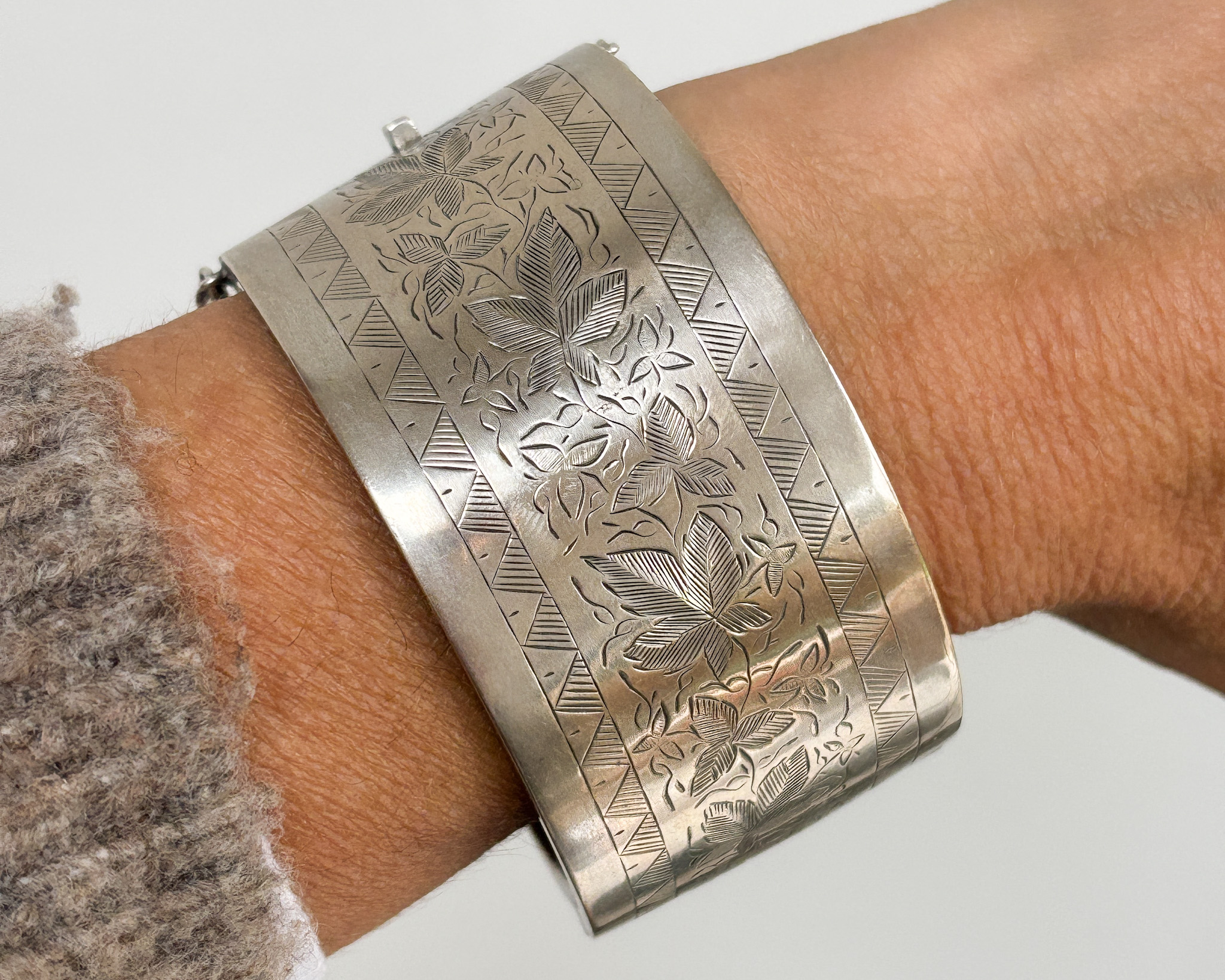 antique Victorian wide silver cuff bangle shown on woman's wrist