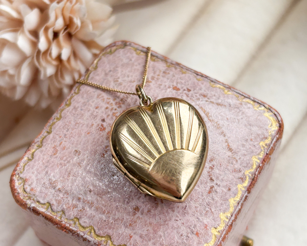 vintage gold sunburst heart locket and chain for sale in Leeds, displayed on a pink box