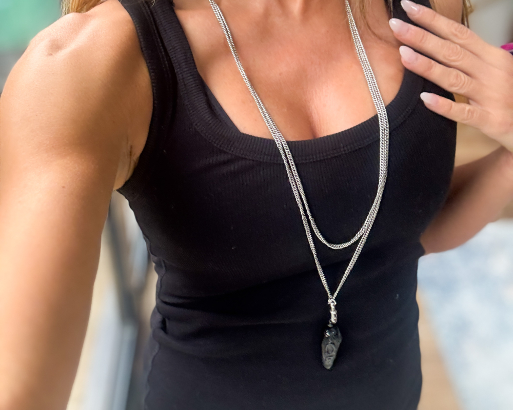 antique silver Victorian muff chain for sale, shown on a woman's neck with a pendant hanging from it