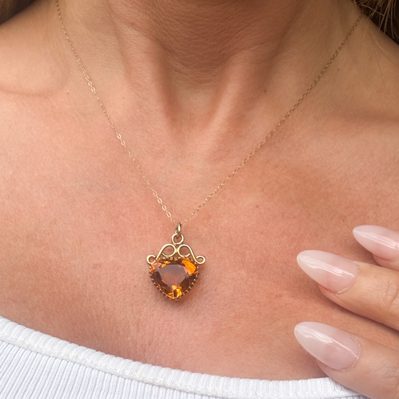 Vintage citrine heart pedant in 9ct gold shown on woman's neck