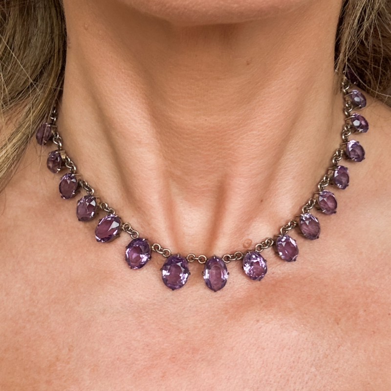 antique Edwardian silver and amethyst riviere necklace in silver. Shown worn on a woman's neck. For sale in Leeds