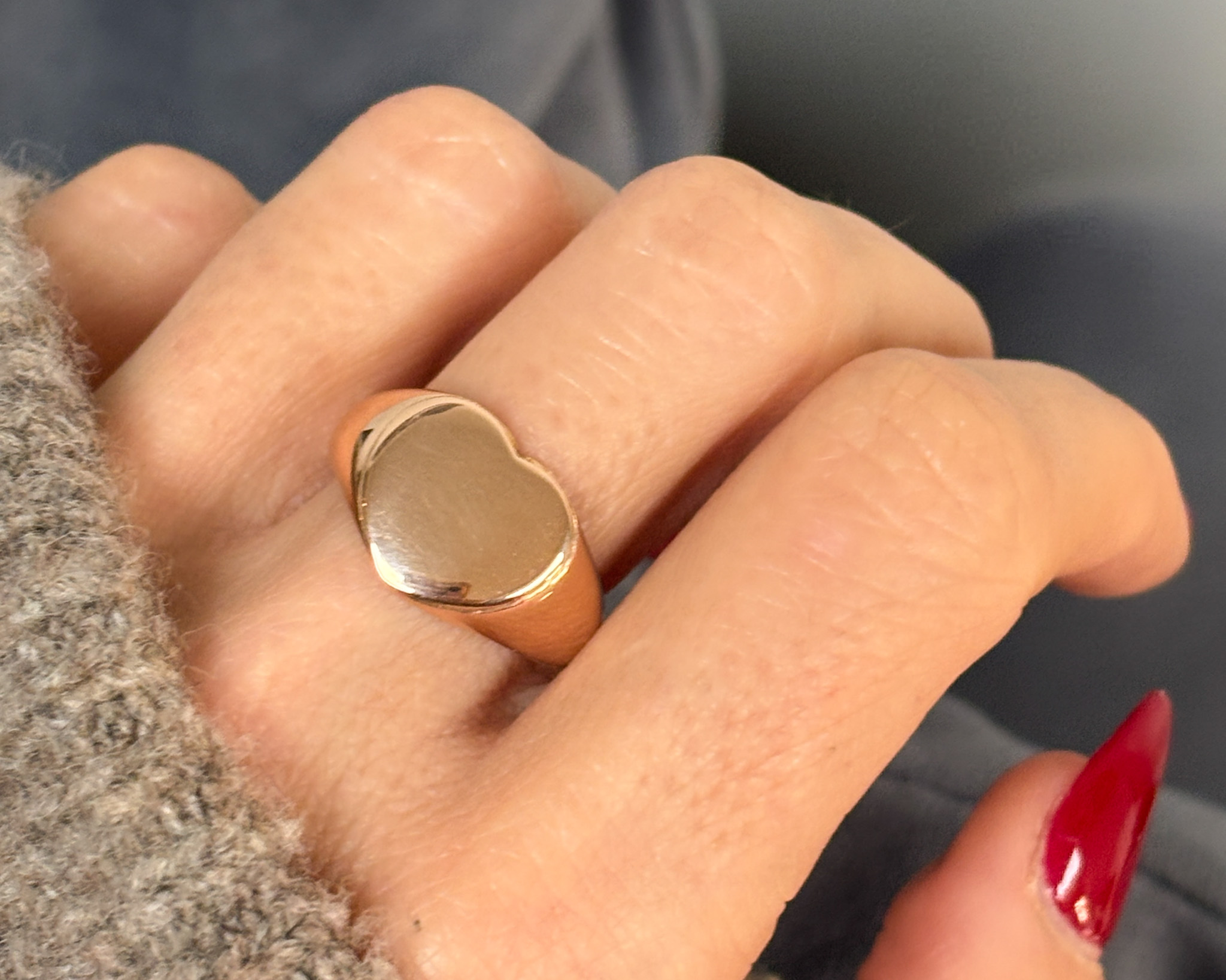 gold heart ring on lady’s hand