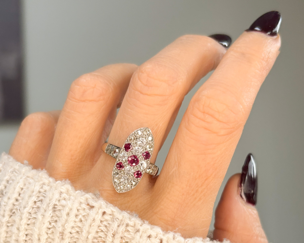 Art Deco ruby and diamond plaque ring with white sapphires, old and rose cut diamonds in 9ct white gold for sale in Leeds, shown on lady's finger