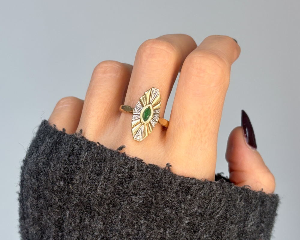 vintage emerald and diamond statement ring on woman's hand