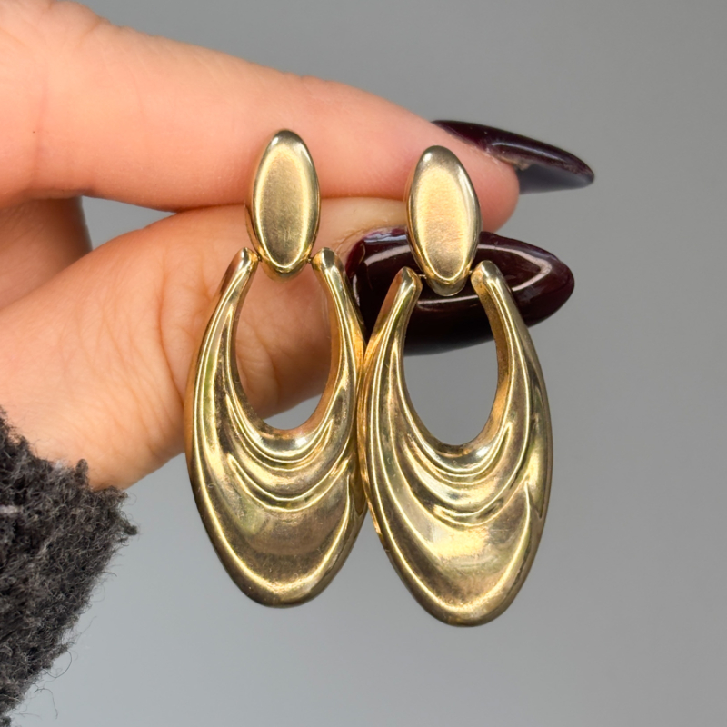 vintage drop earrings in 9ct gold held in woman's fingers