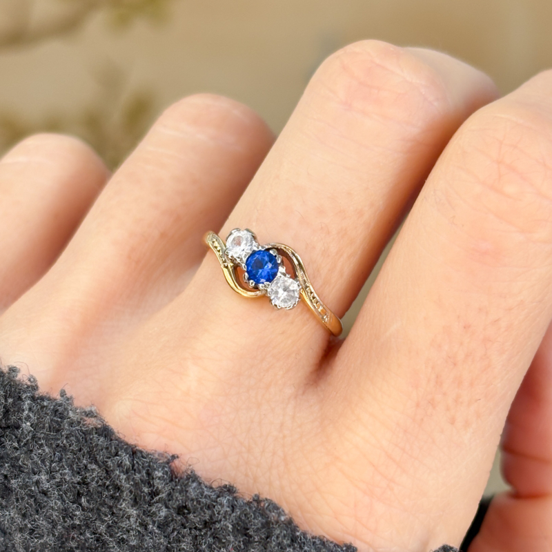 antique bypass ring with blue and white stones in 18ct gold for sale in Leeds, shown on woman's hand