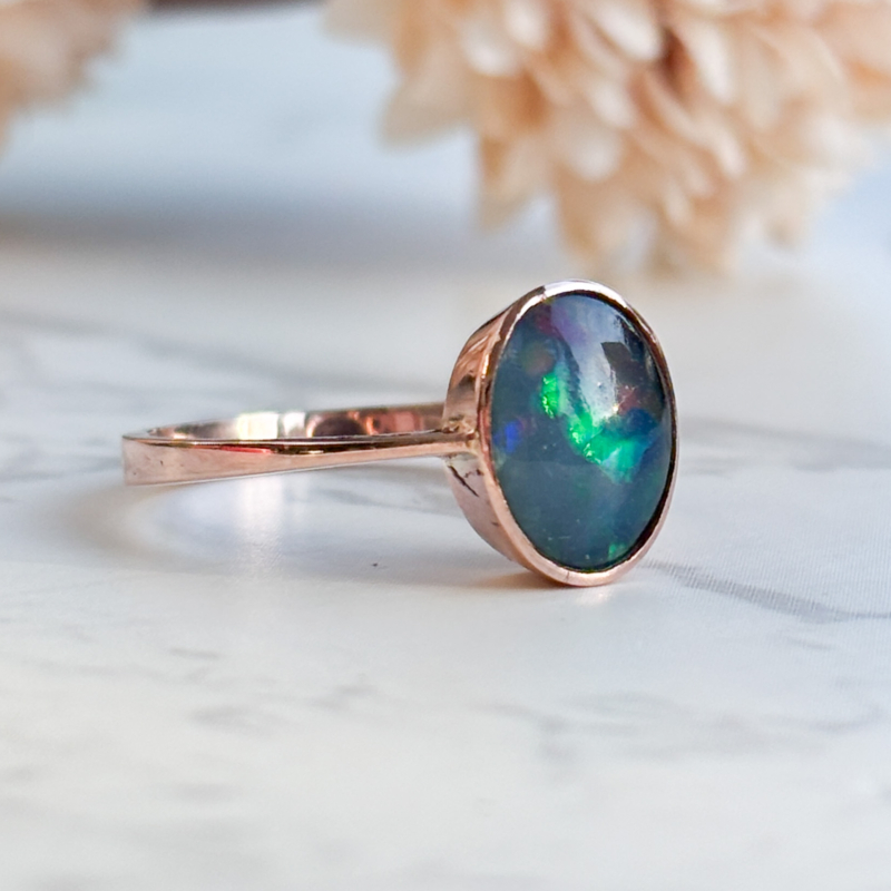modern 9ct rose gold opal ring with dark blue play of colour for sale in Leeds