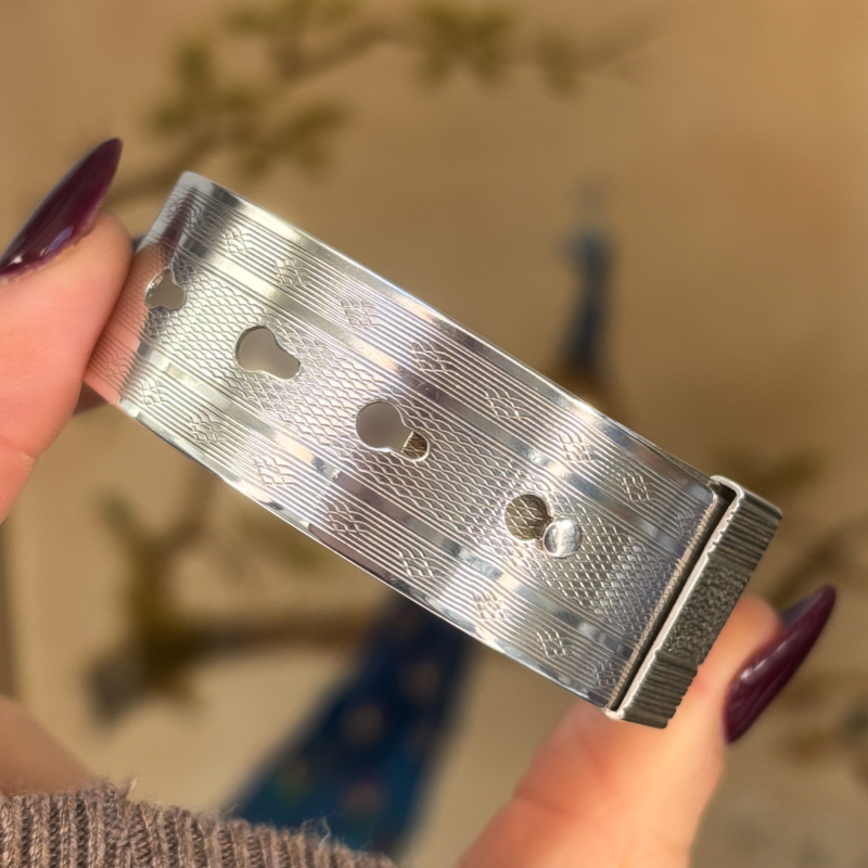 antique Charles Horner silver buckle bangle, held in woman's fingers