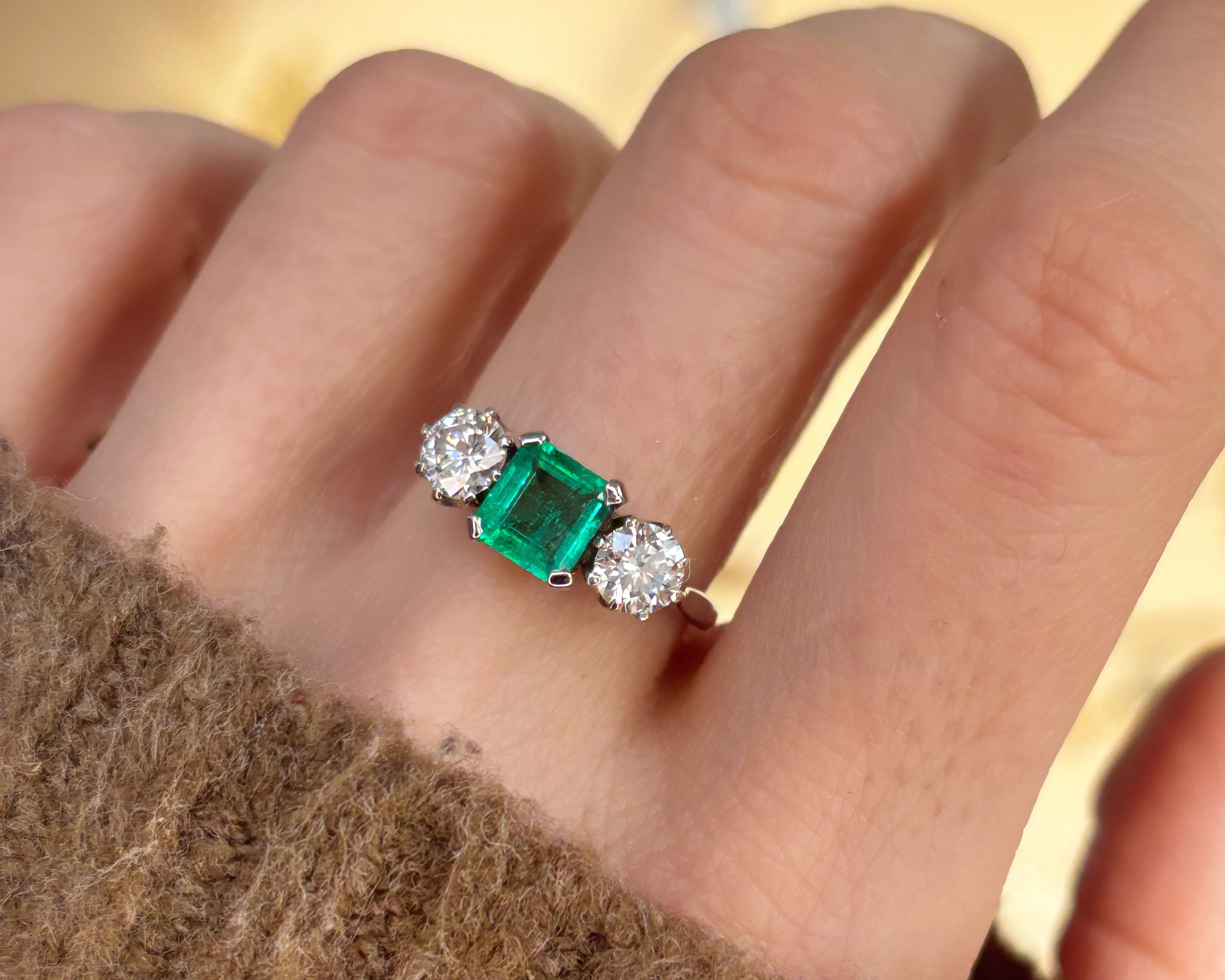 woman wearing emerald and diamond ring