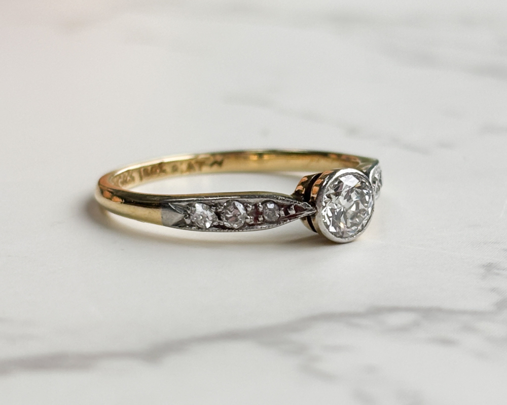 antique Art Deco 1930s diamond solitaire ring approx 0.25ct in 18ct yellow gold and platinum with a bezel setting, showing side of the ring