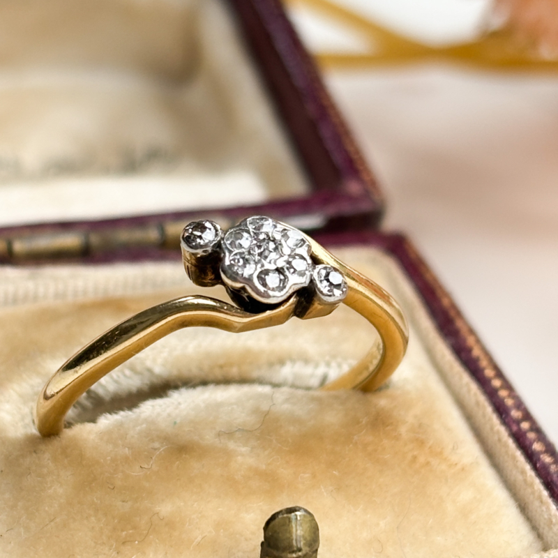 antique 1920s diamond daisy cluster ring in 18ct yellow gold with bypass setting, shown in antique brown box
