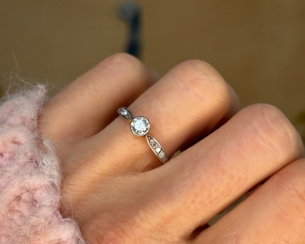 antique Art Deco 1930s diamond solitaire ring approx 0.25ct in 18ct yellow gold and platinum with a bezel setting, shown in a woman's hand