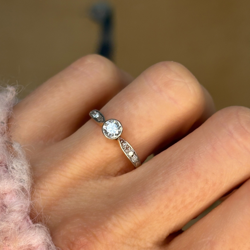 antique Art Deco 1930s diamond solitaire ring approx 0.25ct in 18ct yellow gold and platinum with a bezel setting, shown in a woman's hand