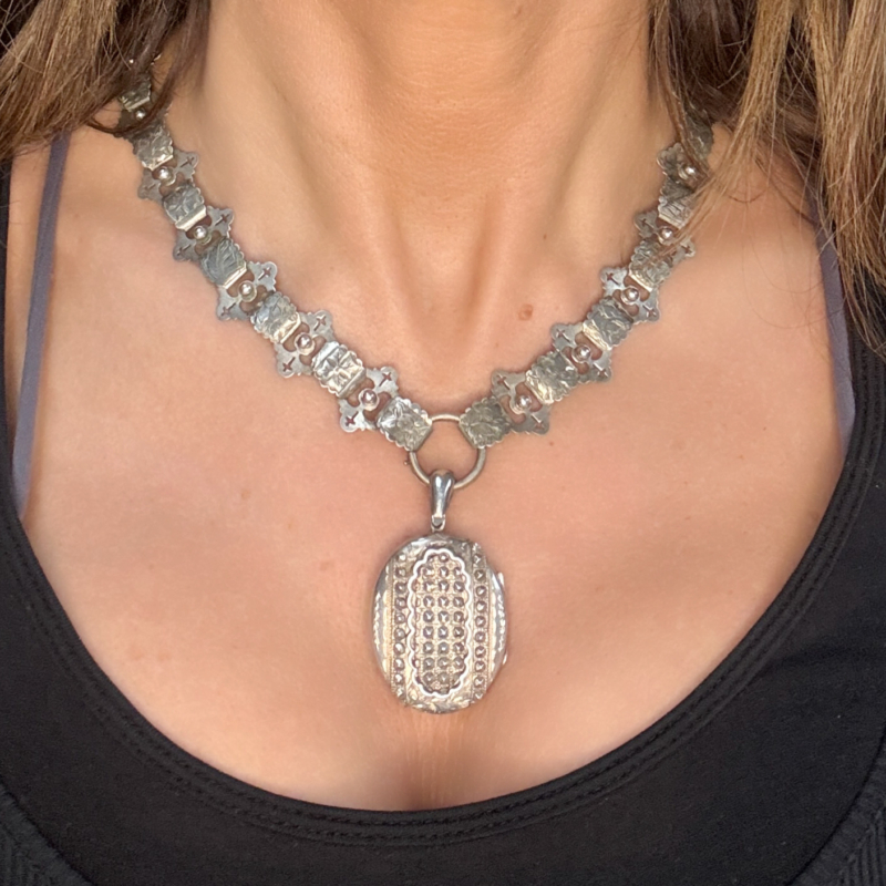 antique Victorian silver book chain and locket for sale shown on a woman's neck