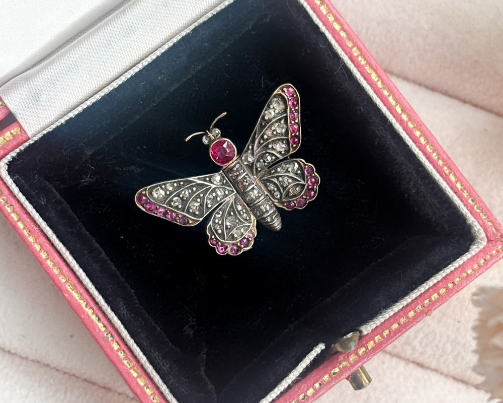 antique Victorian ruby and rose cut diamond butterfly brooch in silver and 14ct gold. For sale in Leeds, shown in a pink box with black inlay