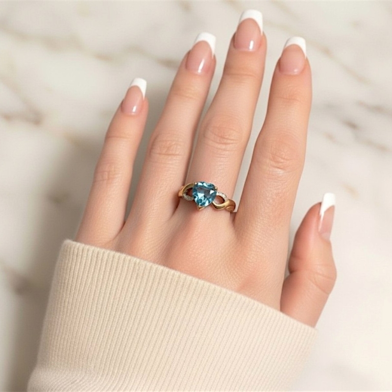 vintage blue topaz heart ring in 9ct gold with diamonds. For sale in Leeds, UK shown on model's hand
