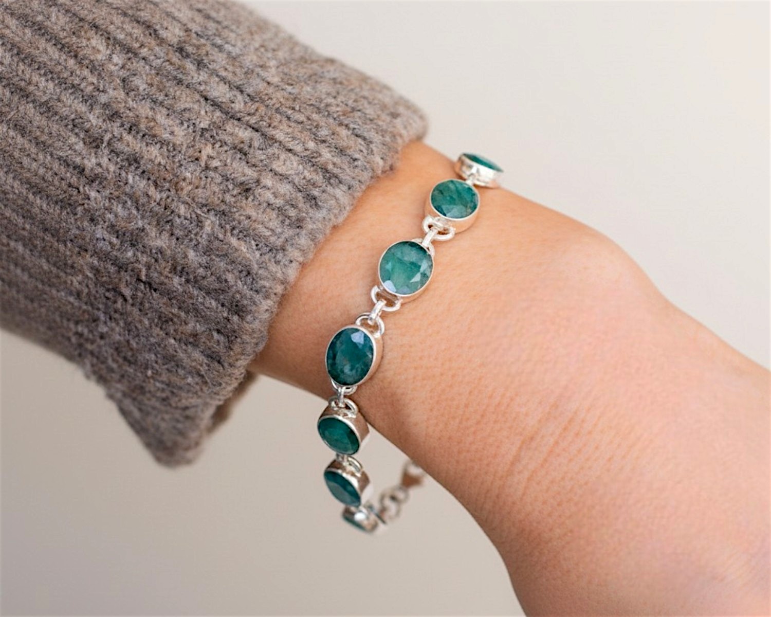 modern silver and emerald bracelet on wrist for sale in Leeds